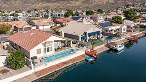 Área residencial com casas, piscina e um cais com barco.