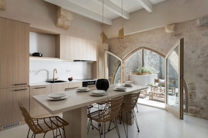 Una cocina moderna con una isla central, armarios de madera y un amplio ventanal con vistas a un jardín.