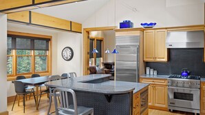 A modern kitchen with a central island, stainless steel appliances, and wooden cabinetry.