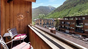 Ein Balkon mit Holzwänden, einem Sonnendekor und zwei Stühlen.