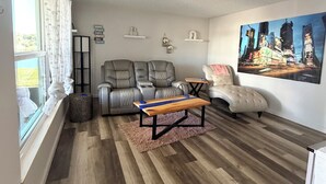 Ein Wohnzimmer mit einer Couch, einem Couchtisch und einem Stadtbild.