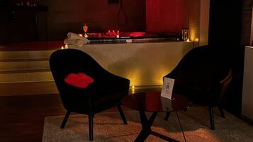 Une chambre d’hôtel comprenant un lit, deux chaises, une petite table et un coin bar.