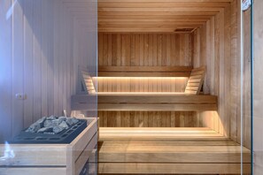 Un sauna avec des bancs en bois et un plancher chauffant.