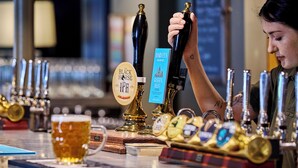 A bar with multiple taps, a glass of beer, and a menu board. - The Black Horse, Climping (Littlehampton)