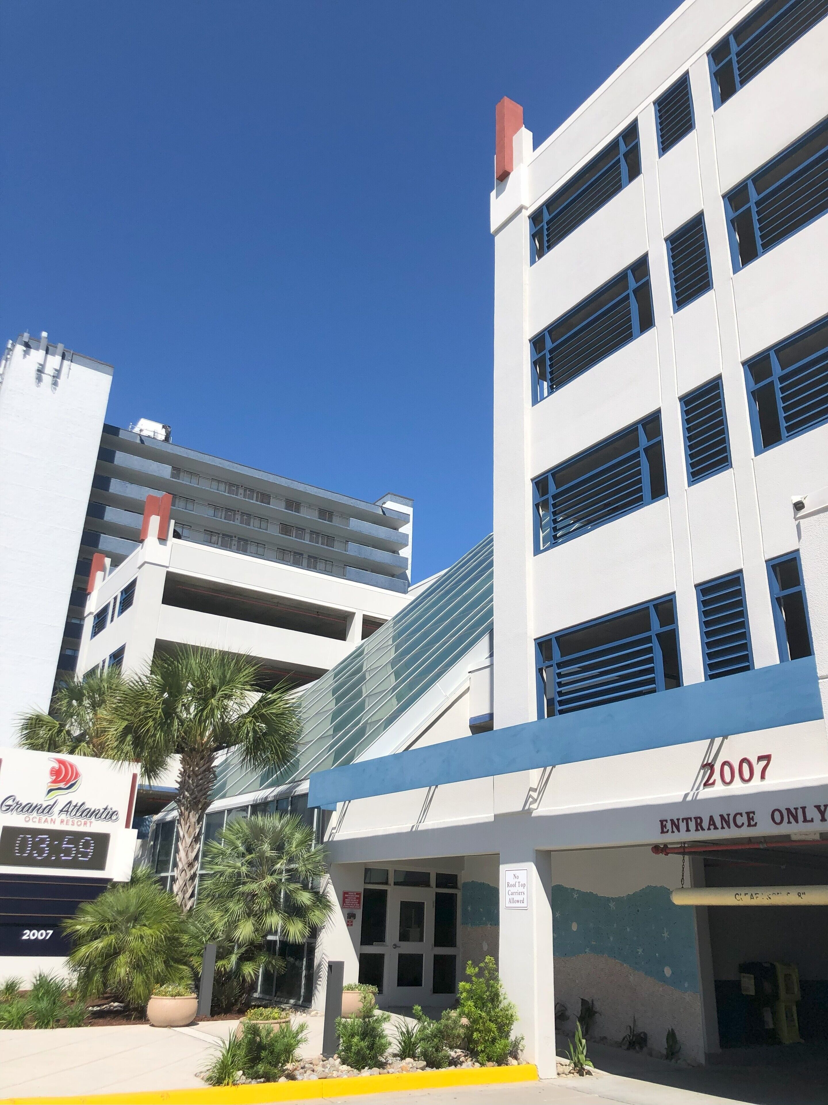 A modern building with a sign indicating 'Grand Atlantic Ocean Resort' and 'Entrance Only'.