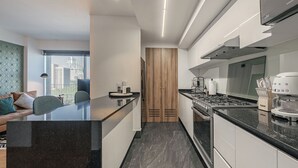Une cuisine moderne dotée d’un îlot central, d’appareils électroménagers intégrés et offrant une vue sur la ville.