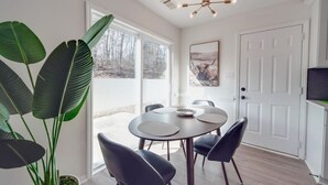 A dining area with a round table, black chairs, and a potted plant. - Fully Updated 3-BR Ranch Escape—Near USNWC/Airport (Charlotte)