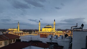 Vista de un edificio histórico con múltiples cúpulas y minaretes, rodeado de edificios modernos.