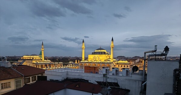 Vista de un edificio histórico con múltiples cúpulas y minaretes, rodeado de edificios modernos.
