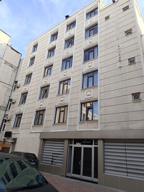 A multi-story hotel with a beige facade, large windows, and a ground-level entrance with a glass door. - Pirotel Hotel  (Konya)