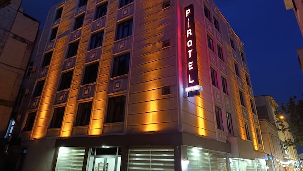 Un hotel de varios pisos con un llamativo letrero de neón que dice "Pirotel".
