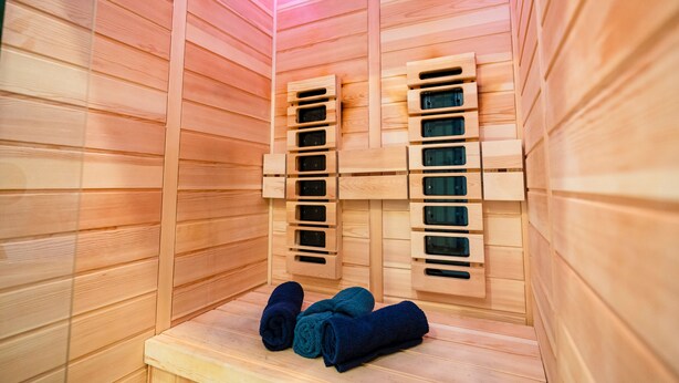 A sauna with wooden walls and benches, and towels on the floor. - Le Rex - Bel appt avec sauna (Nantes)
