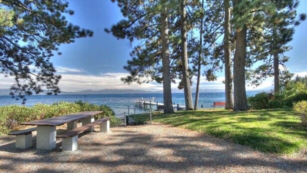 Un área de picnic con bancos y vistas al agua.