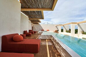 A rooftop pool area with red seating and a clear view of the sky. - Bacab Tulum (Tulum)