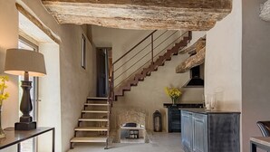 A spacious living area with a staircase leading to a loft bedroom, a kitchen area, and a dining table with a lamp. - Villa Serena - Private villa with pool in Umbria (Umbertide)
