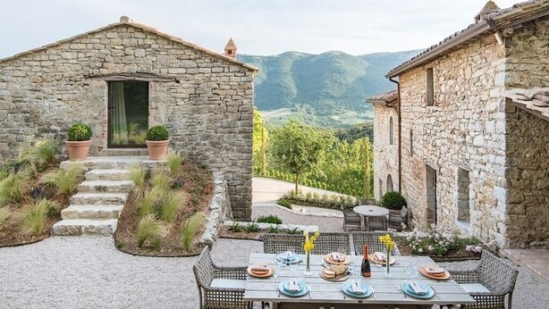 A stone building with a table set for dining, surrounded by a gravel path and potted plants. - Villa Serena - Private villa with pool in Umbria (Umbertide)