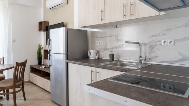 A modern kitchen with a built-in oven, a sink, and a marble backsplash. - Danai Maisonettes Ofriniou  (Pangaio)