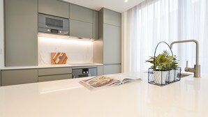 A modern kitchen with grey cabinets, a built-in oven, and a stainless steel faucet. - Haverstock Hill Serviced Apartments by Concept Apartments (London)