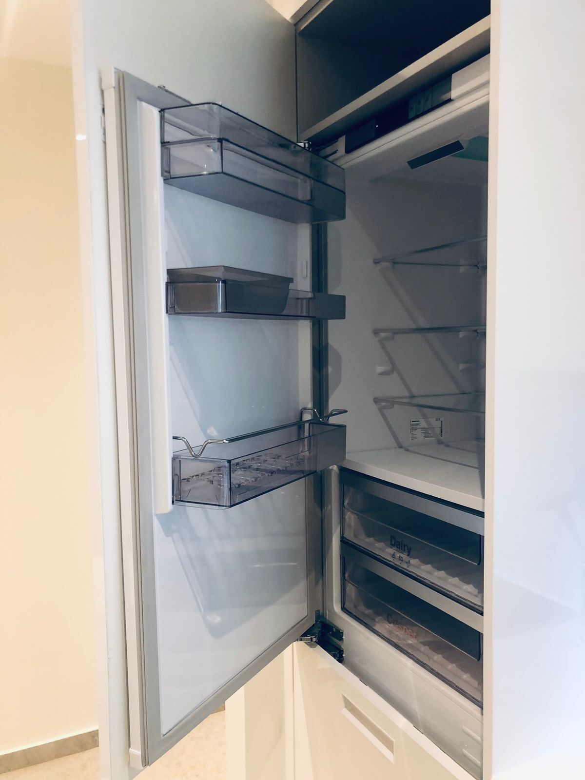 An open refrigerator with multiple shelves and a freezer compartment.