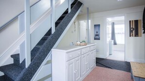 A staircase with a dark granite finish, a white built-in bench with drawers, and a pink carpeted area.