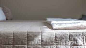Una cama bien hecha con cubrecolcha acolchada y almohadas.