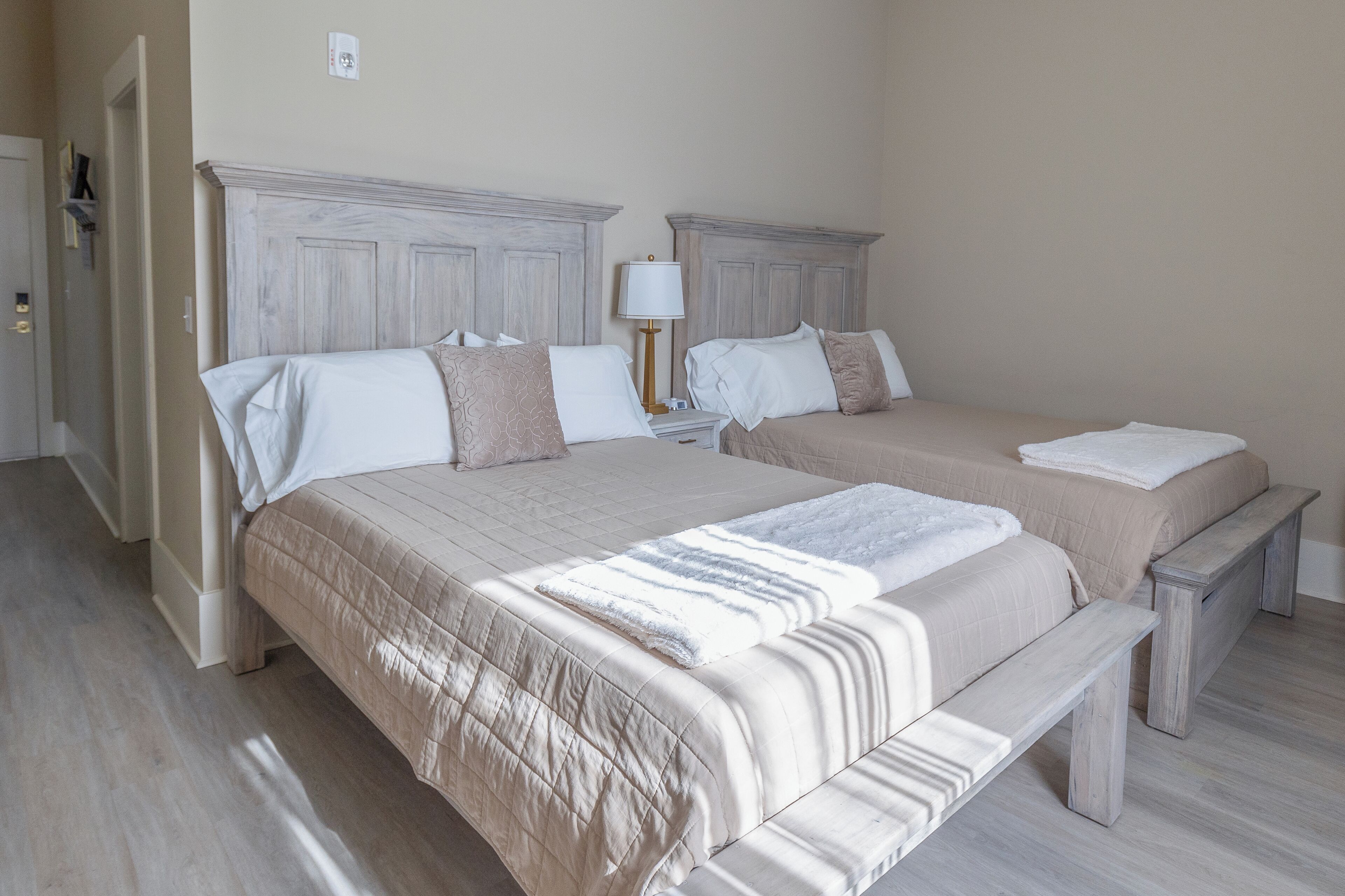 A double bed with a bench, two bedside tables, and a lamp.