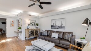 A modern living room with a sofa, coffee table, and a ceiling fan. - Premier location in Scottsdale close to Old town & Open- HEATED pool & jacuzzi😎 (Paradise Valley)