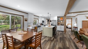 Un'ampia cucina con zona pranzo, ampie finestre e vista sull'esterno.