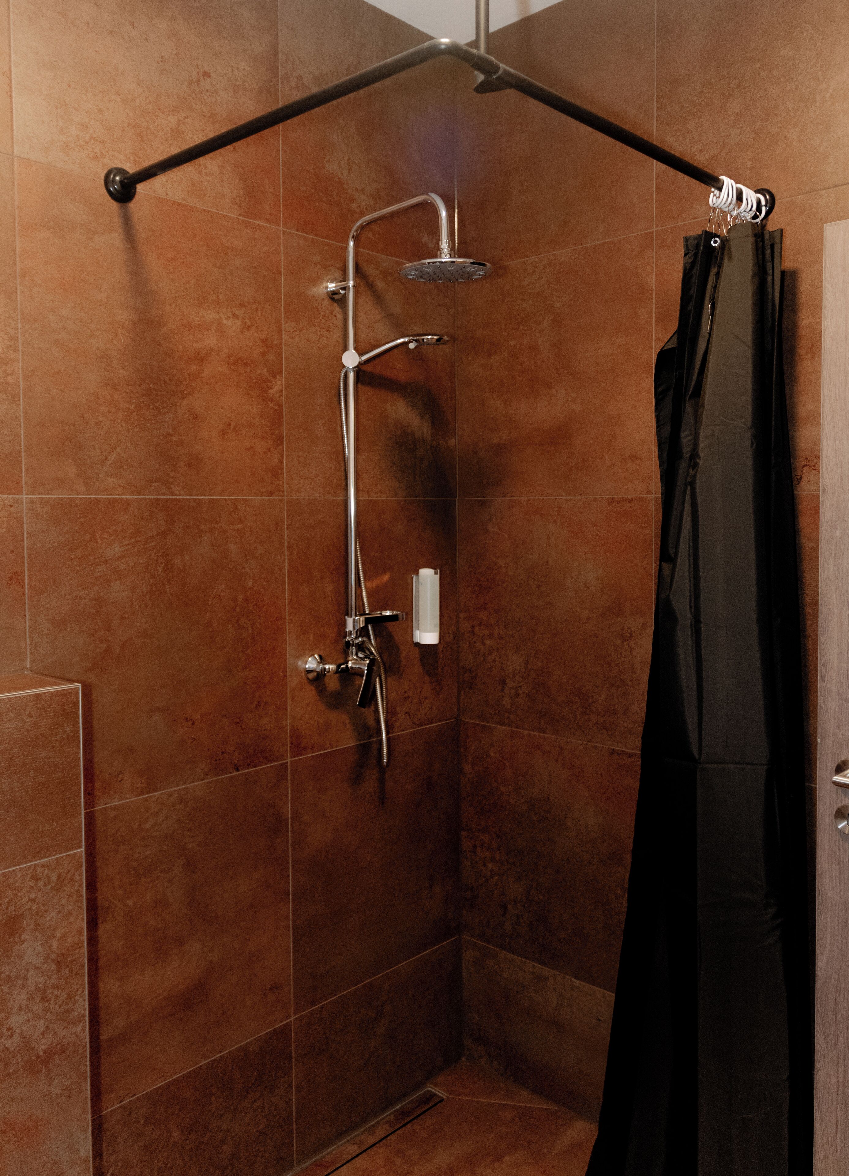 Un espace douche équipé d’un pommeau de douche à main, d’un robinet mural et d’un porte-serviettes.
