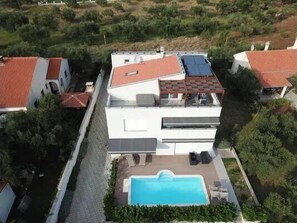 Enjoy a refreshing swim in the large pool surrounded by a paved deck area with lounge chairs.