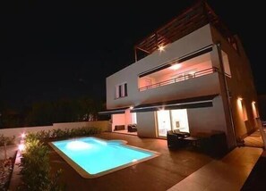 Enjoy a refreshing swim in the pool surrounded by an outdoor space.