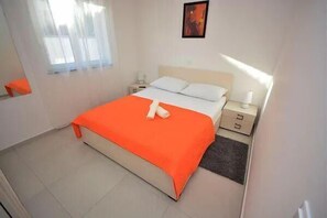 Relax in a spacious room with a large bed, nightstand, and framed picture.