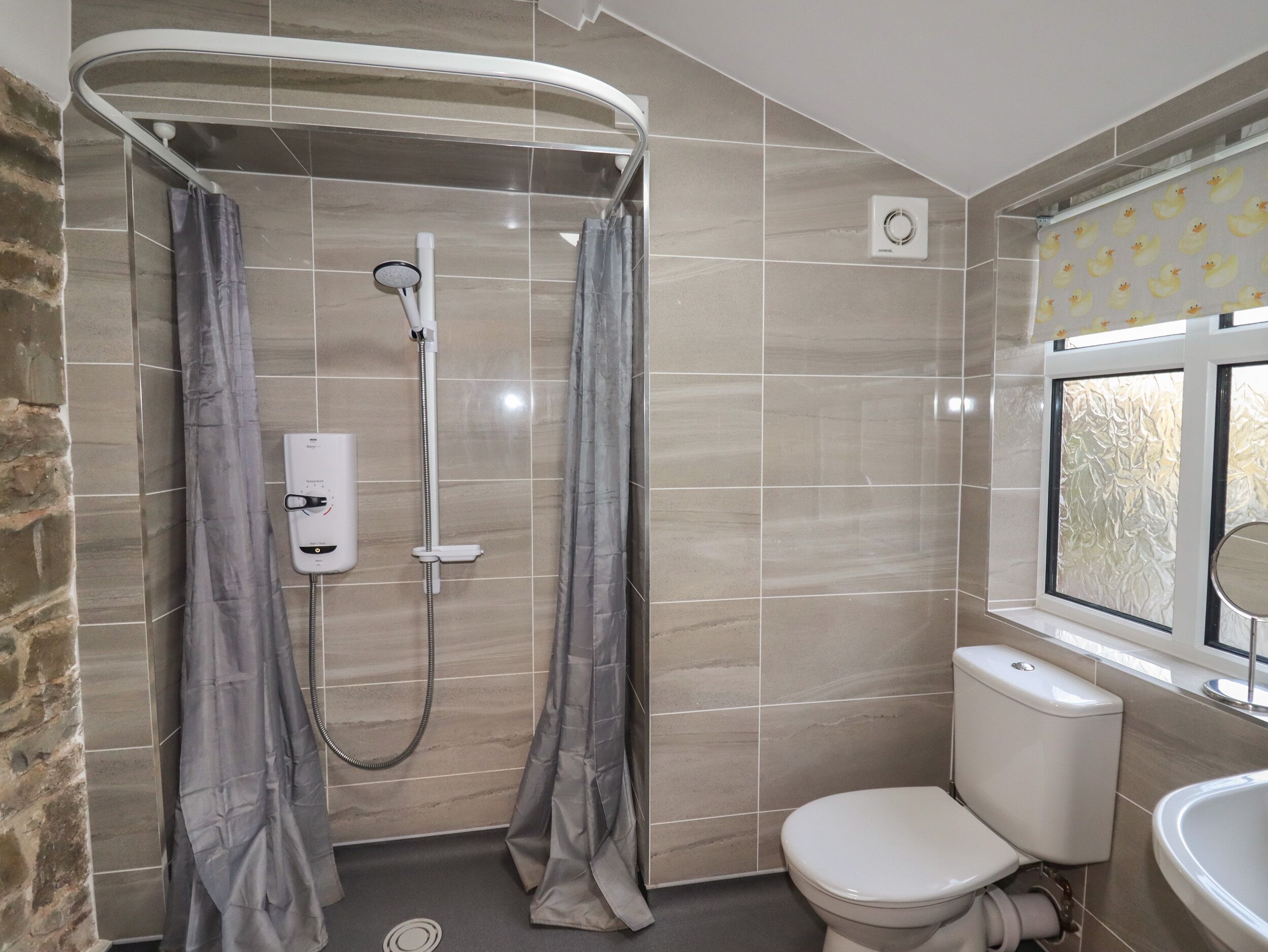 A bathroom with a shower, toilet, and sink.