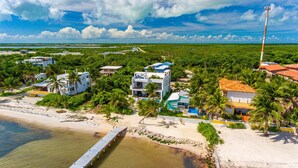 Une propriété située sur la côte, comprenant plusieurs bâtiments, un quai et une plage.