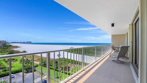Ein Balkon mit Blick auf Strand und Meer.