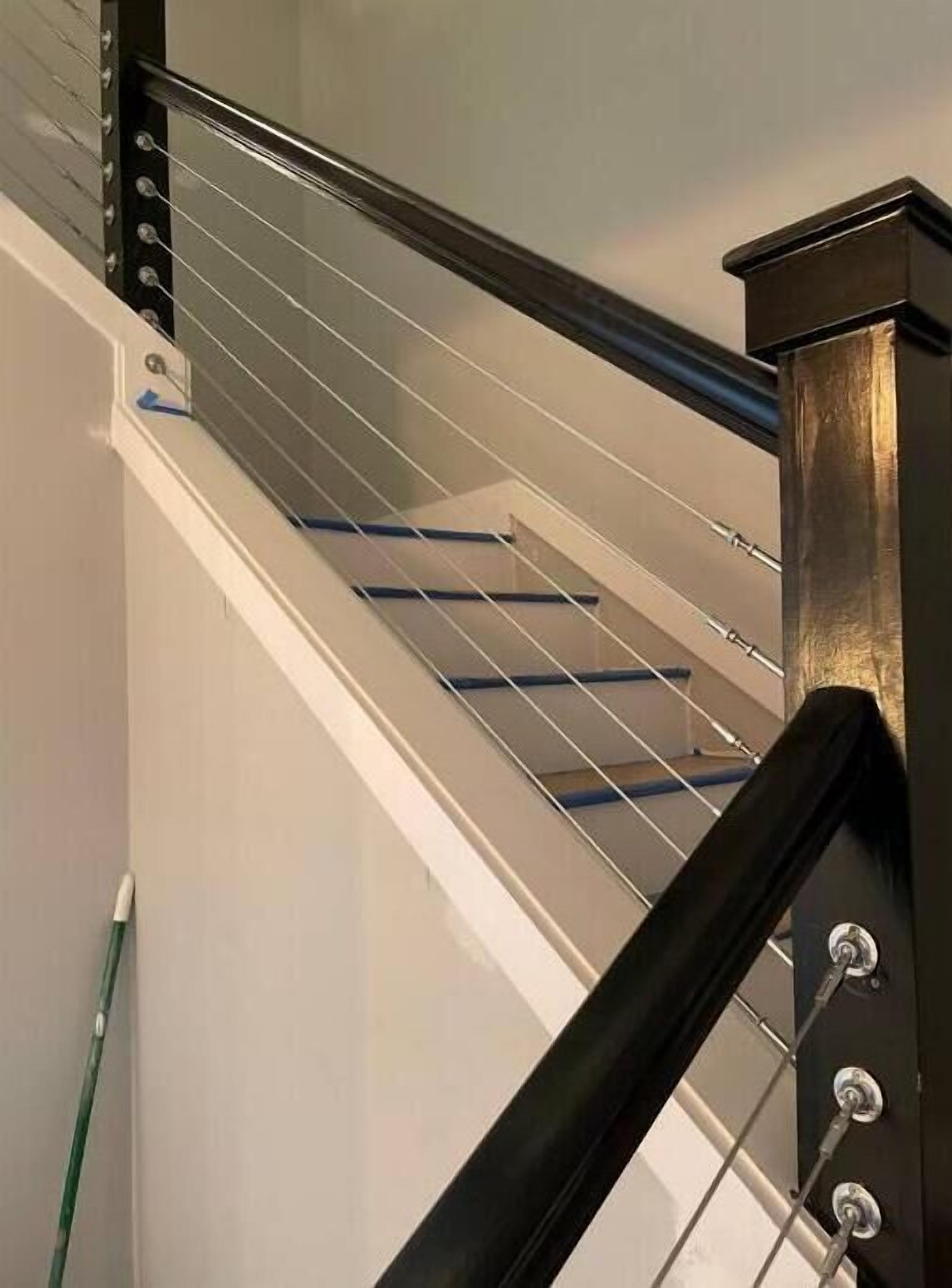 A staircase with metal railings and a black handrail.