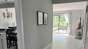 A spacious, well-lit interior with a dining area, a kitchen, and a large sliding glass door leading to an outdoor area. - Perfect for Golfer's, P-baller's and Beach Goer's! (Hilton Head Island)