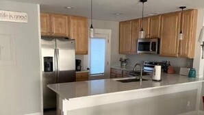 A modern kitchen with wooden cabinets, stainless steel appliances, and a central island. - Perfect for Golfer's, P-baller's and Beach Goer's! (Hilton Head Island)