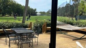A wooden deck with a table and chairs, overlooking a golf course. - Perfect for Golfer's, P-baller's and Beach Goer's! (Hilton Head Island)