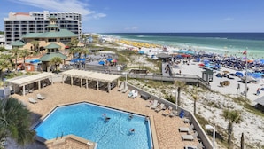 Ein Resort mit Swimmingpool, Strandbereich und einem großen Gebäude mit mehreren Balkonen.