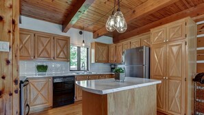 A kitchen with wooden cabinets, a stainless steel refrigerator, and a dishwasher. - Charmante, spacieuse maison canadienne/Charming and very spacious Canadian house (Saint-Jérôme)