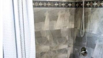 Ein Badezimmer mit einer Badewanne, einer Dusche und einer gefliesten Wand.