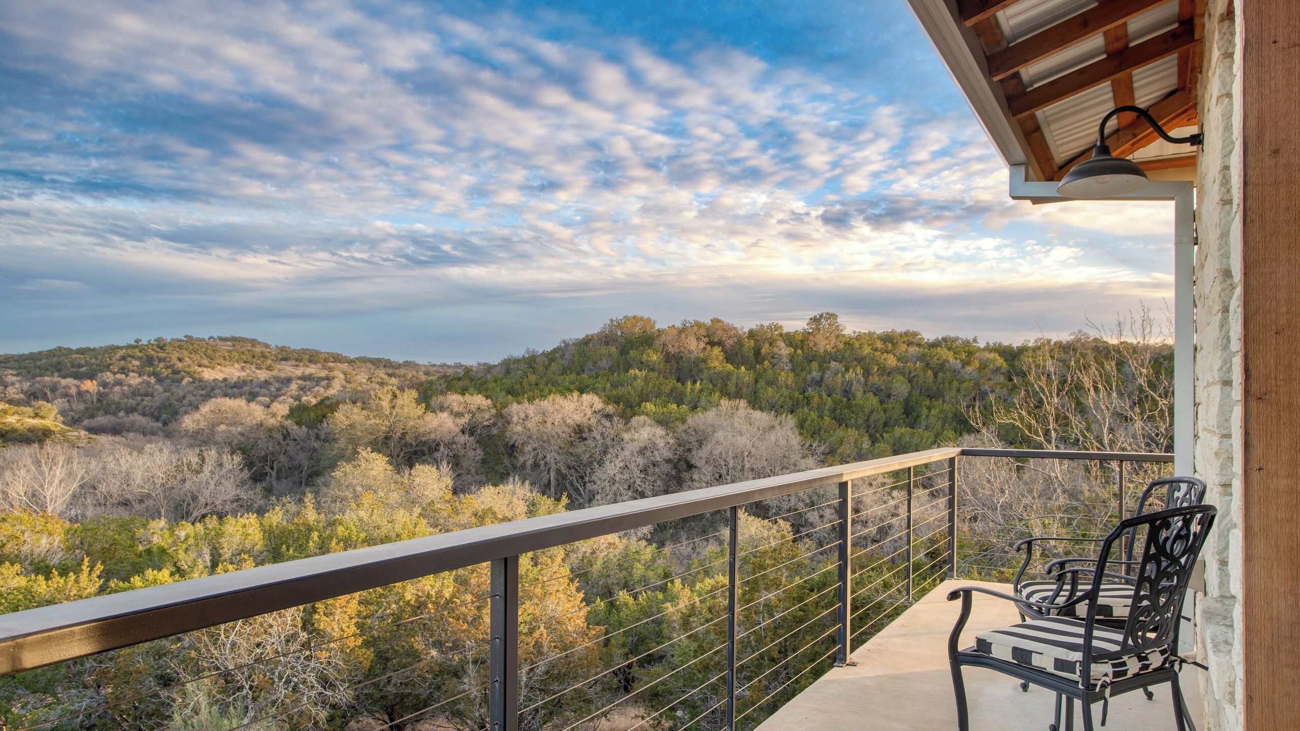 A balcony with a view of a forested hillside.