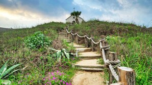 A pathway leading to a small building with a cross on top, surrounded by greenery and a cloudy sky. - Jones N by the Beach by Avantstay Walk to Beach (Port Aransas)