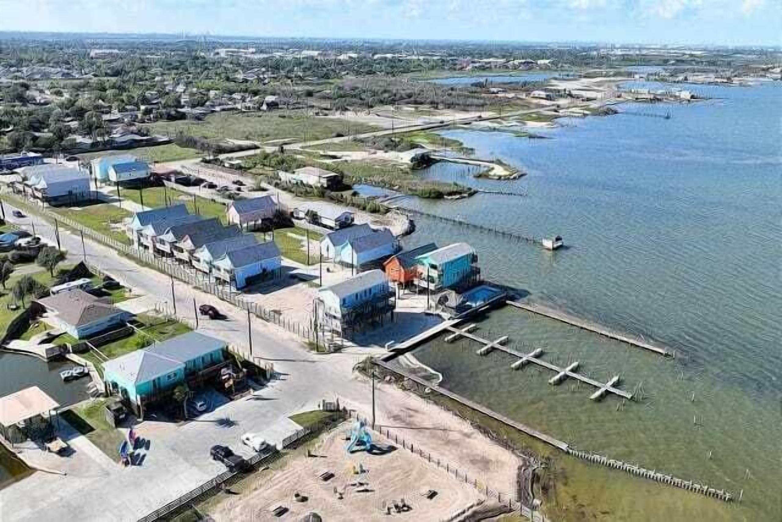 Vue aérienne d’une zone côtière comprenant de nombreux bâtiments, des quais et une marina.