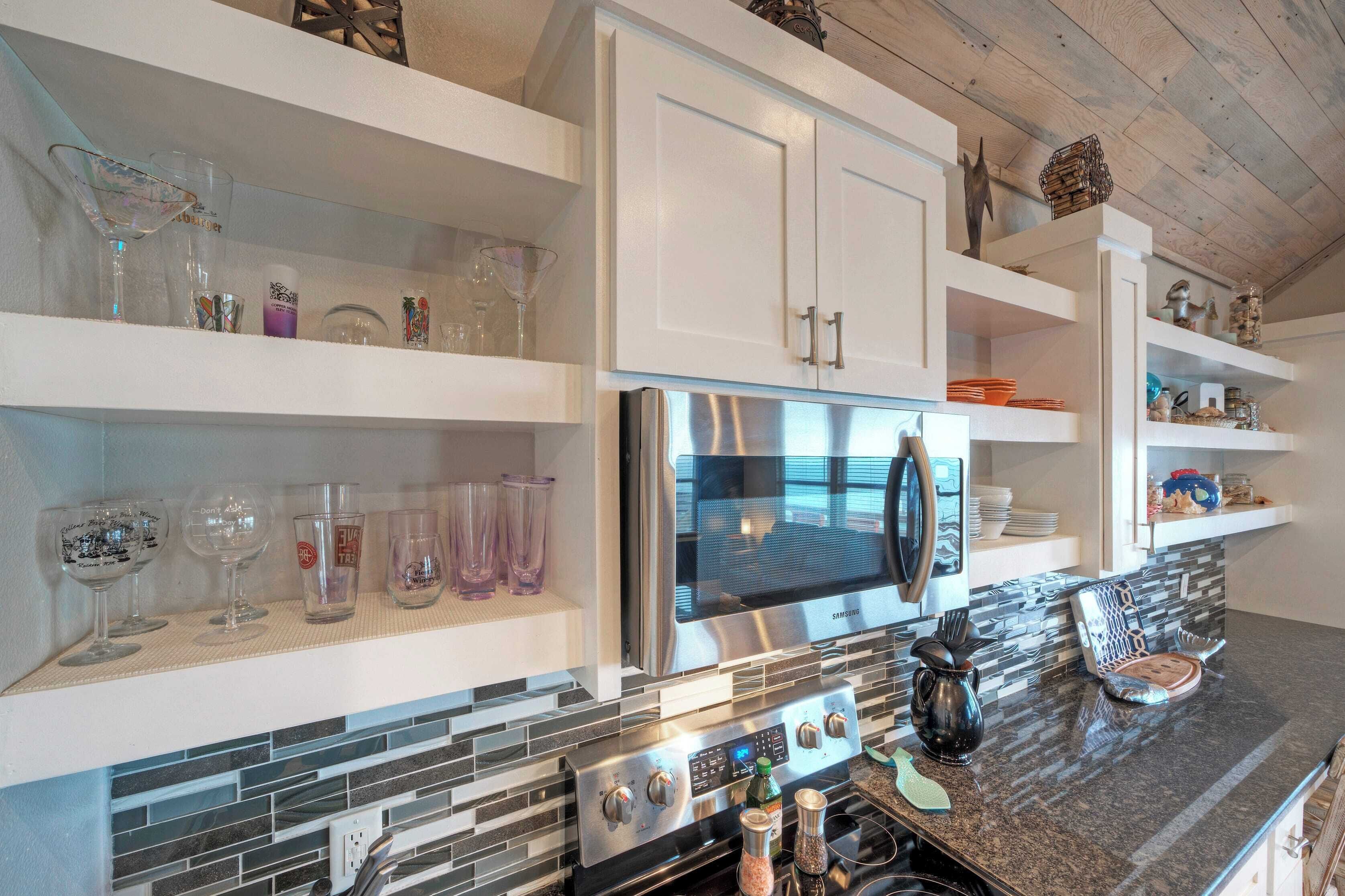 A modern kitchen with white cabinetry, a stainless steel refrigerator, and a tiled backsplash.