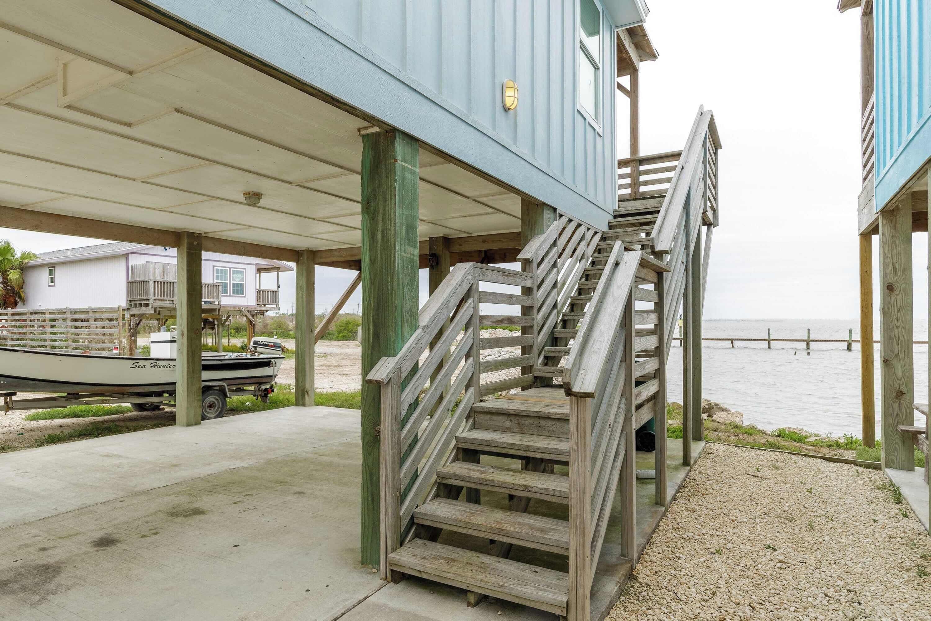 A wooden staircase leading to a covered area with a view of the water.