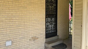 A brick exterior with a black metal gate and steps leading to a porch. - Edward's Place ~ Family Retreat Near Downtown & Oaklawn (Hot Springs)