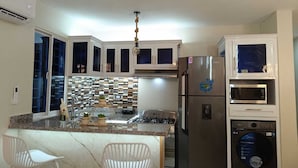 Una cocina moderna con una isla central, electrodomésticos integrados y un salpicadero original.