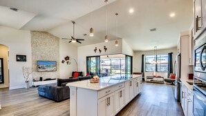 A spacious kitchen with a large island, modern appliances, and a view to the outdoors. - Special Offer Villa Felicity - river access, pool & spa, quiet, charming (Cape Coral)